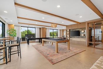 Game Lounge with billiards, shuffleboard, wet bar, and multi-sport golf simulator at Lilia Apartments in Lilydale, MN 55118